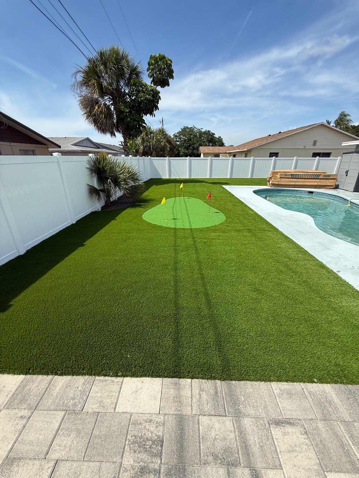 Artificial turf beside a pool with a small putting green