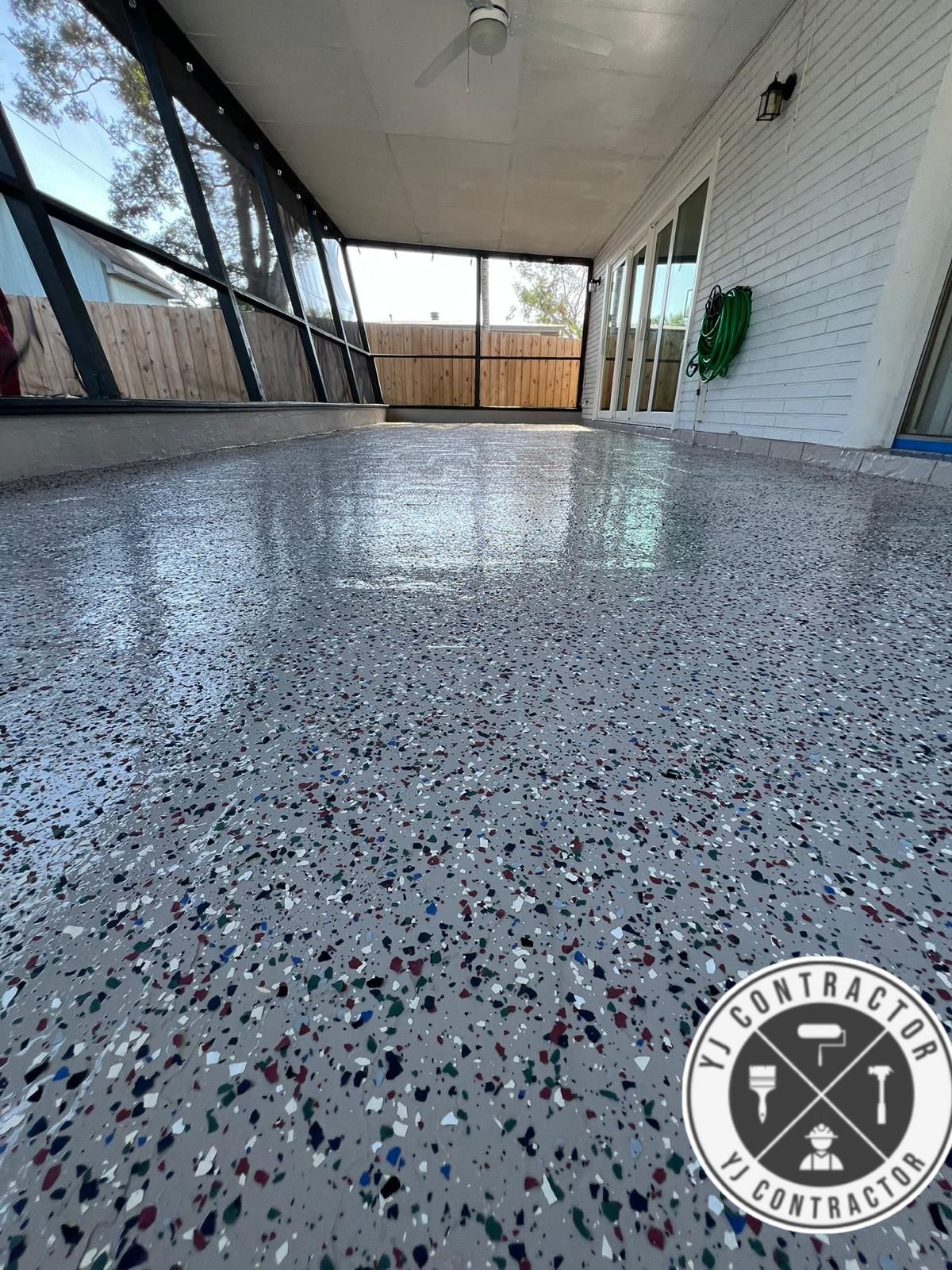 Light flake epoxy flooring across a covered patio