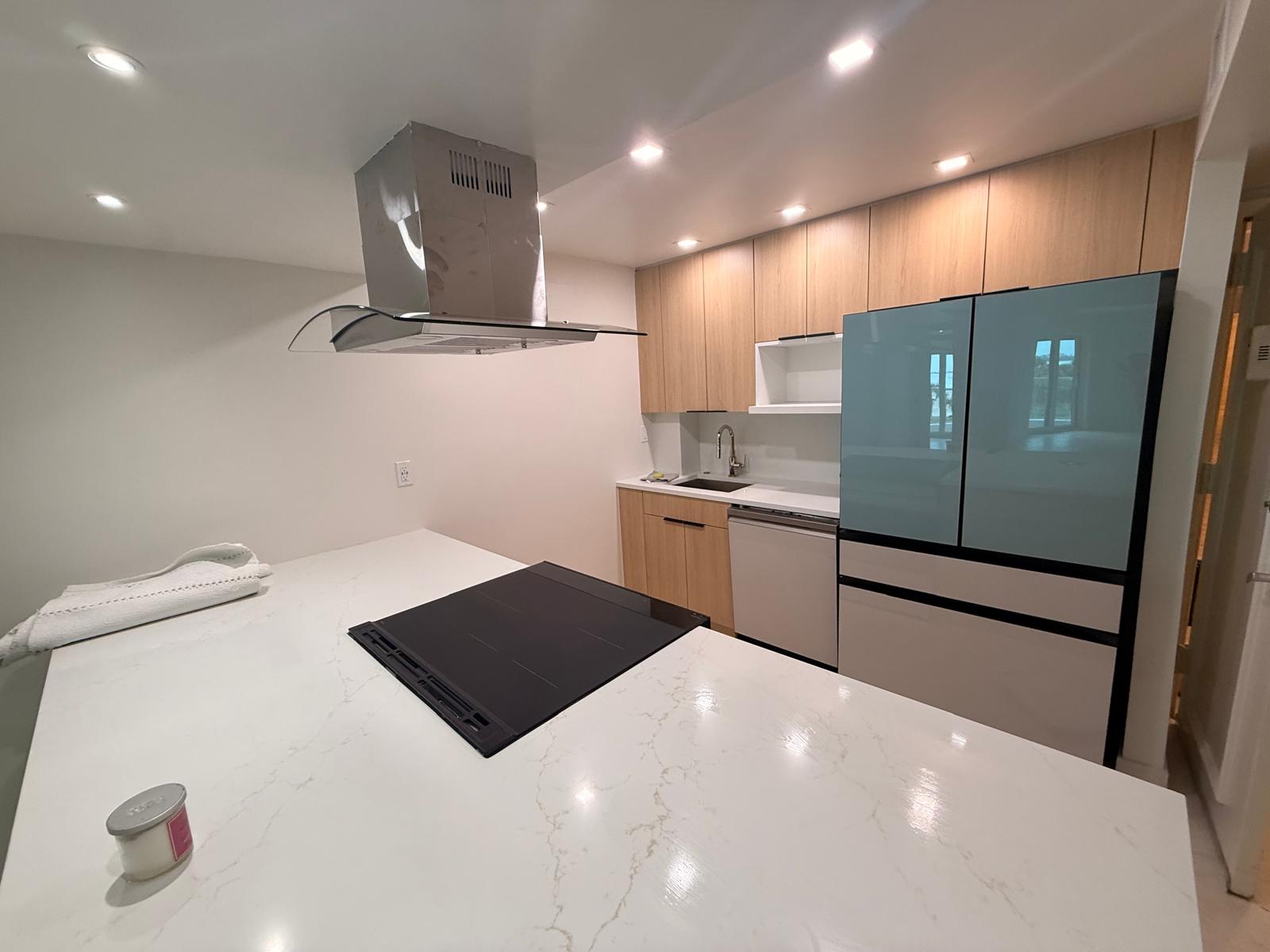 Remodeled kitchen with custom cabinetry and a white stone-look countertop