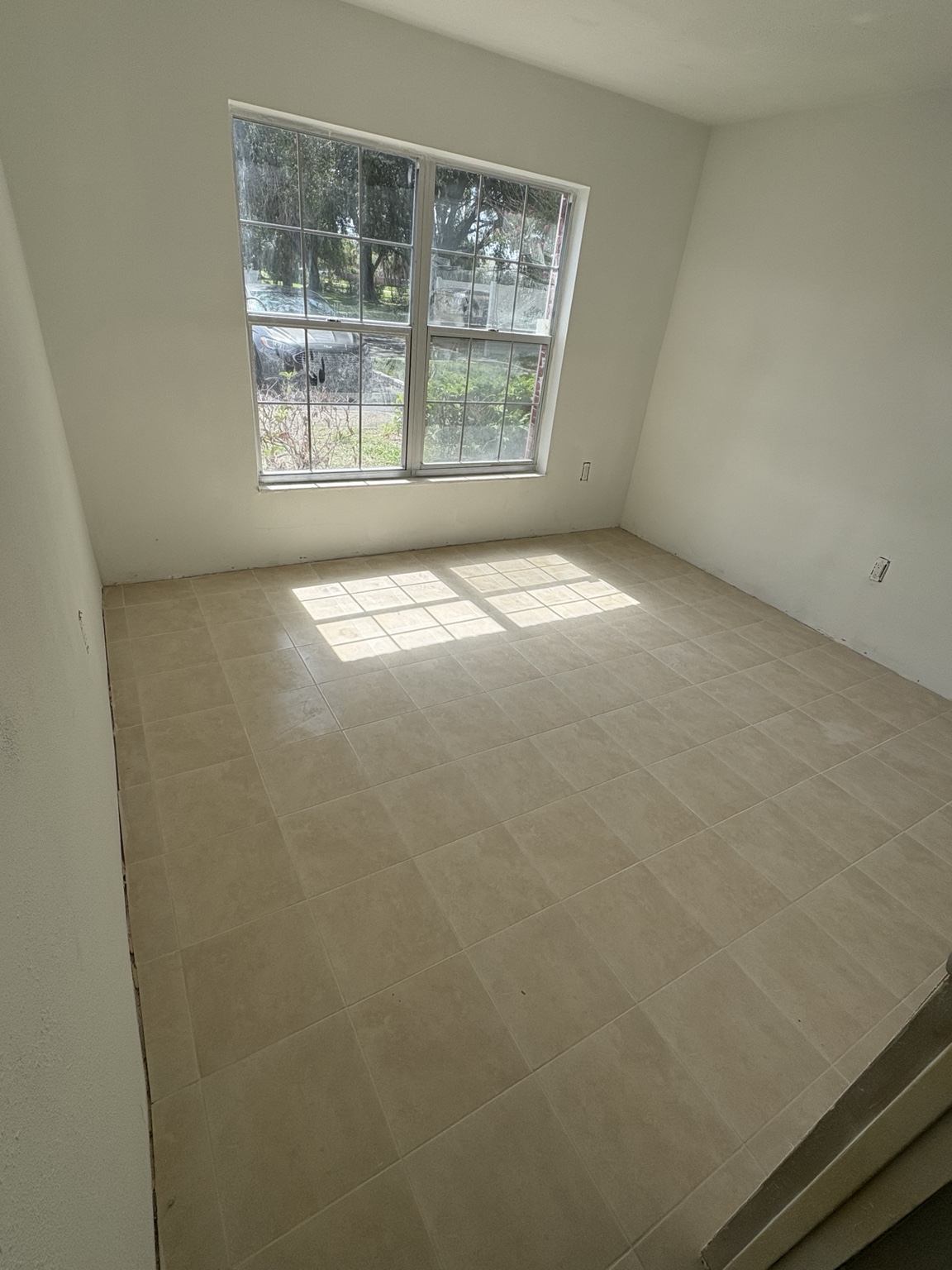 Finished light-colored floor tile in a bright room