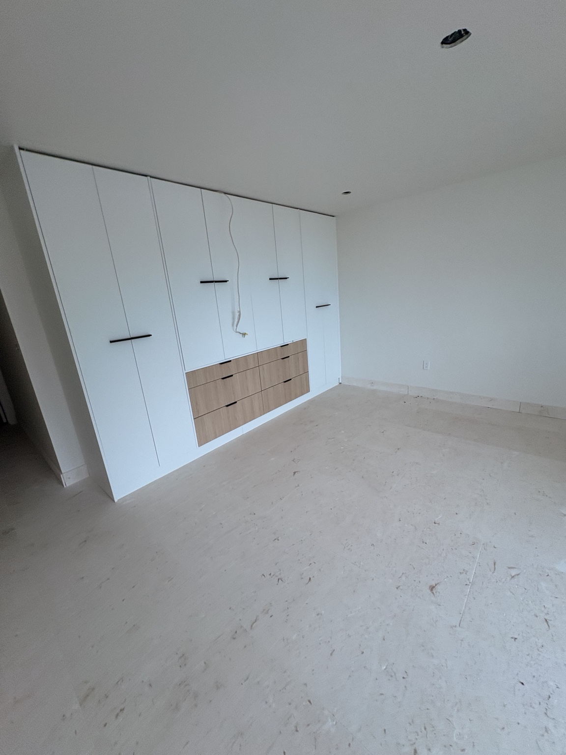 Travertine floor in a room with built-in cabinetry