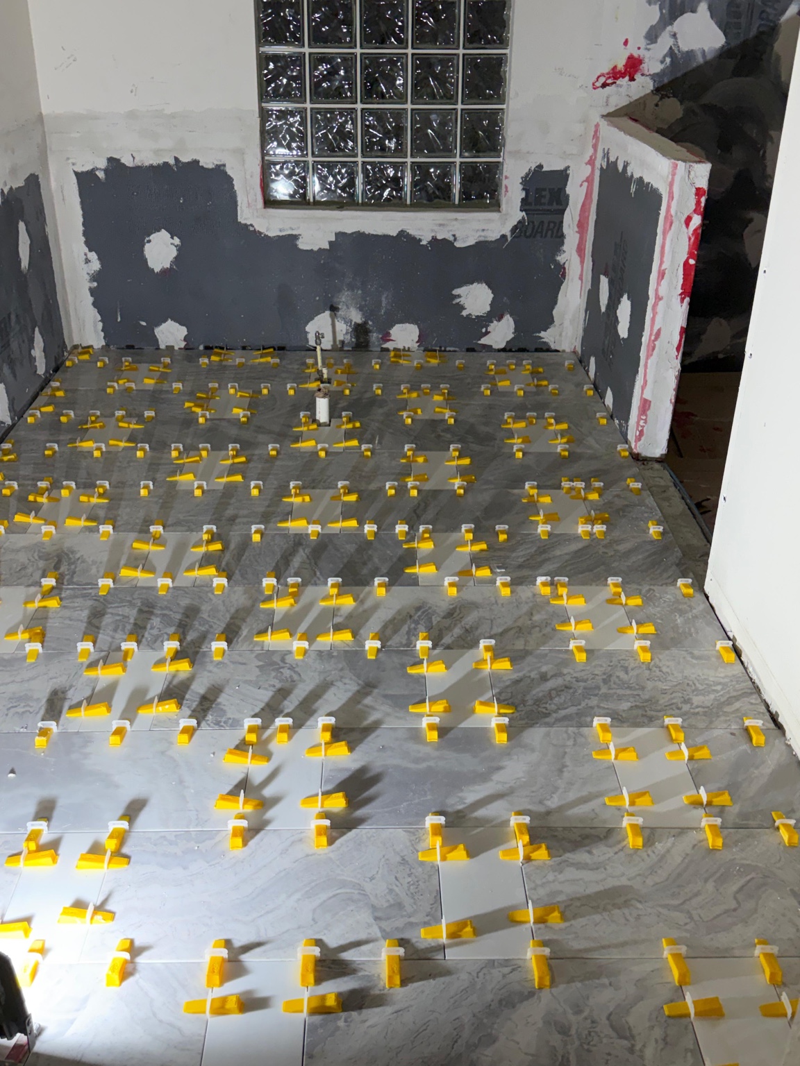Stone tile being installed with leveling clips